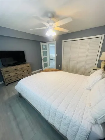a bedroom with a bed and a flat tv screen on dresser