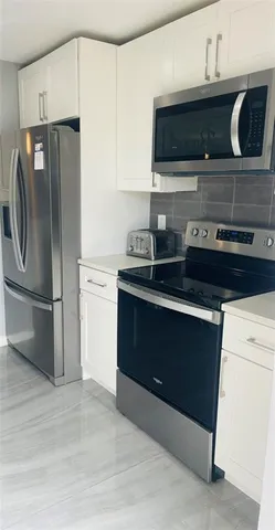 a kitchen with stainless steel appliances and cabinets