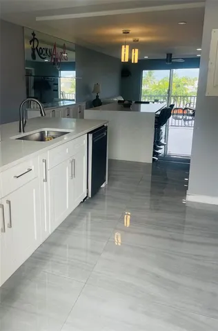 a kitchen with kitchen island granite countertop a sink and a stove