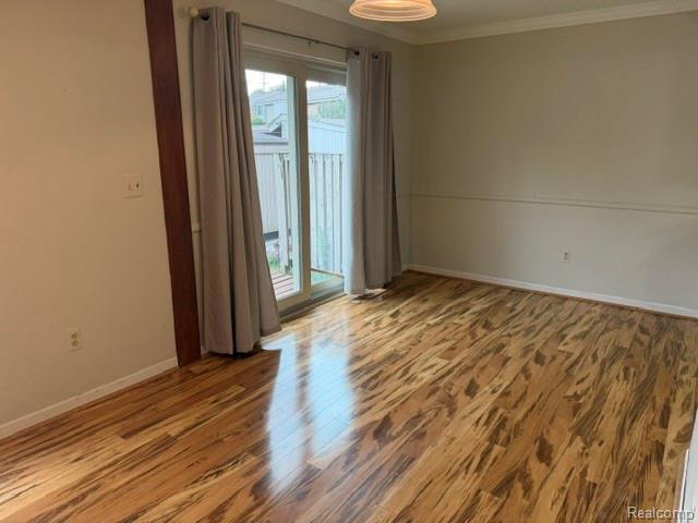 629 Oakbrook West, Unit 18 Rochester, MI 48307 - Photo 13 of 18 Wood-finish flooring, sliding glass door, crown molding, and a built-in overhead light fixture