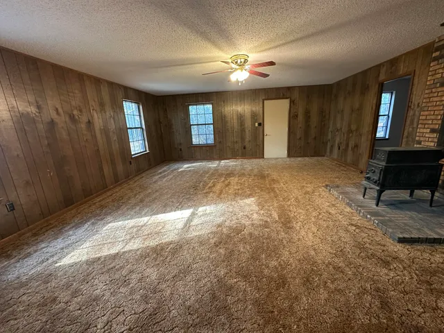 a view of an empty room with window and bathroom