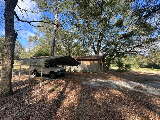 a view of a yard with a bench and trees