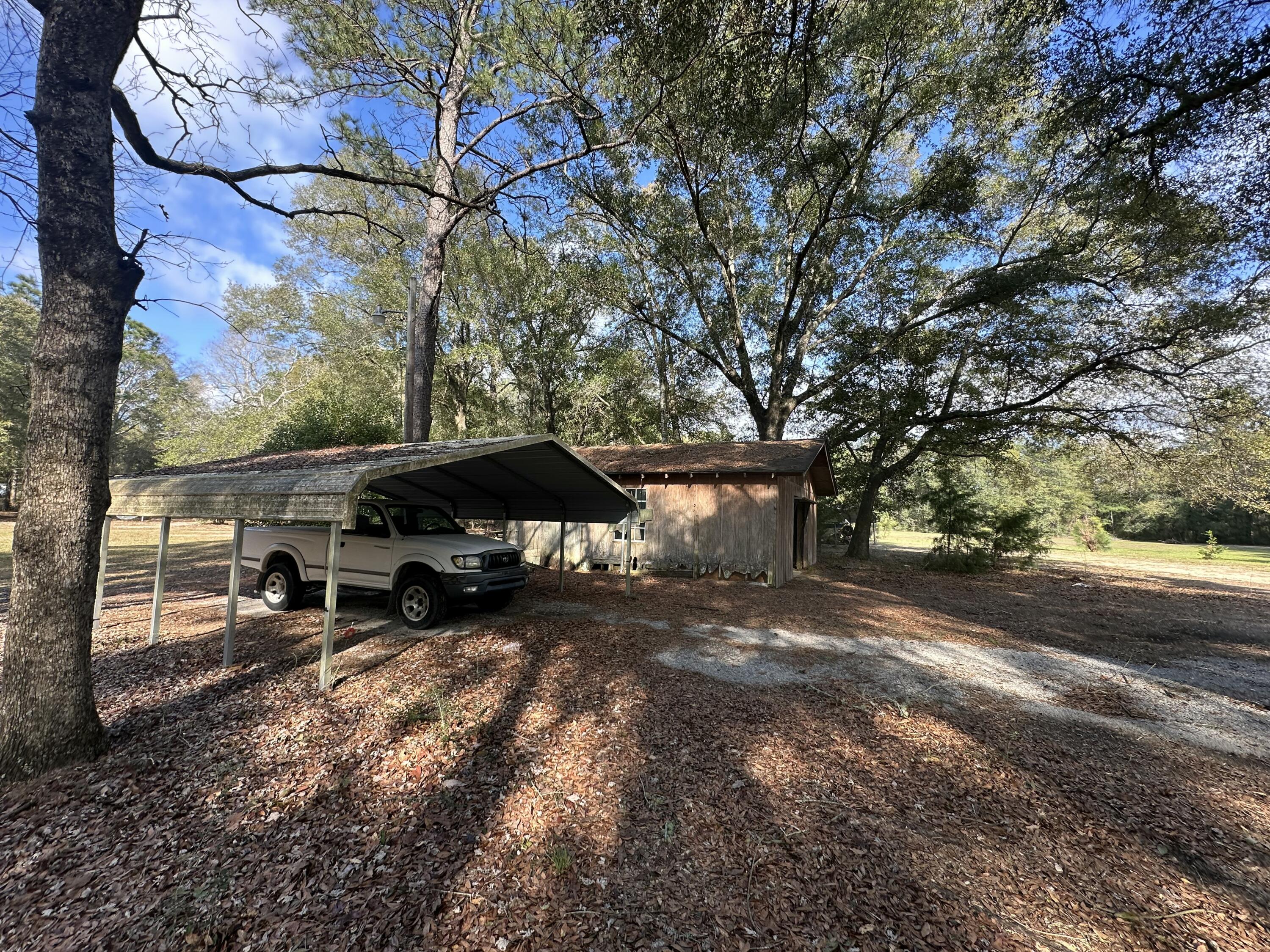 5895 Pineforest Drive Crestview, FL 32539 - Photo 3 of 23 a view of a yard with a bench and trees