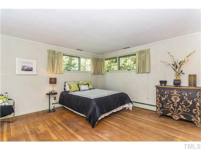 829 Bryan Street Raleigh, NC 27605 - Photo 11 of 23 a bedroom with a bed windows and a chandelier