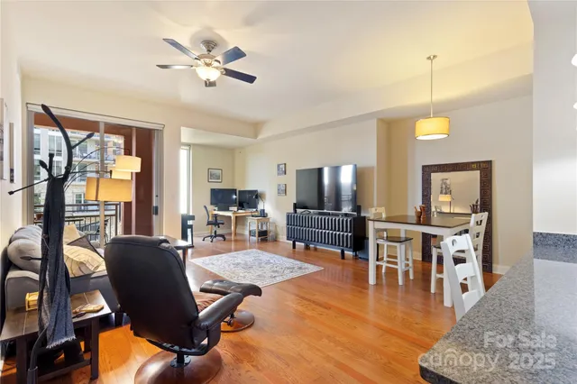 a living room with furniture dining table and a floor to ceiling window