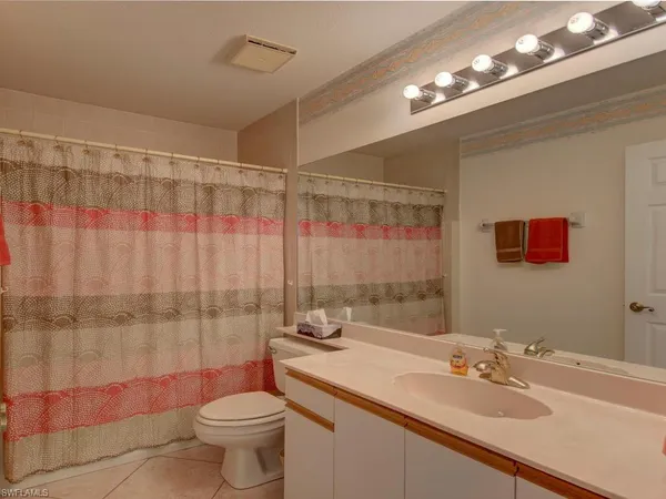 a bathroom with a sink vanity mirror and toilet