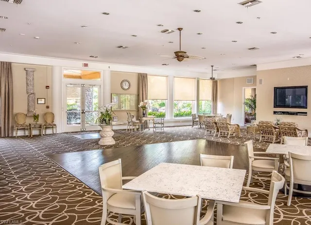 a dining hall with couches a flat tv screen and a dining table with garden view