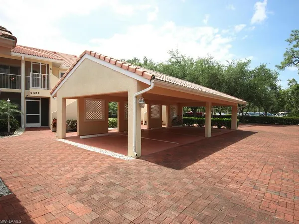 a front view of a house with a yard and potted plants