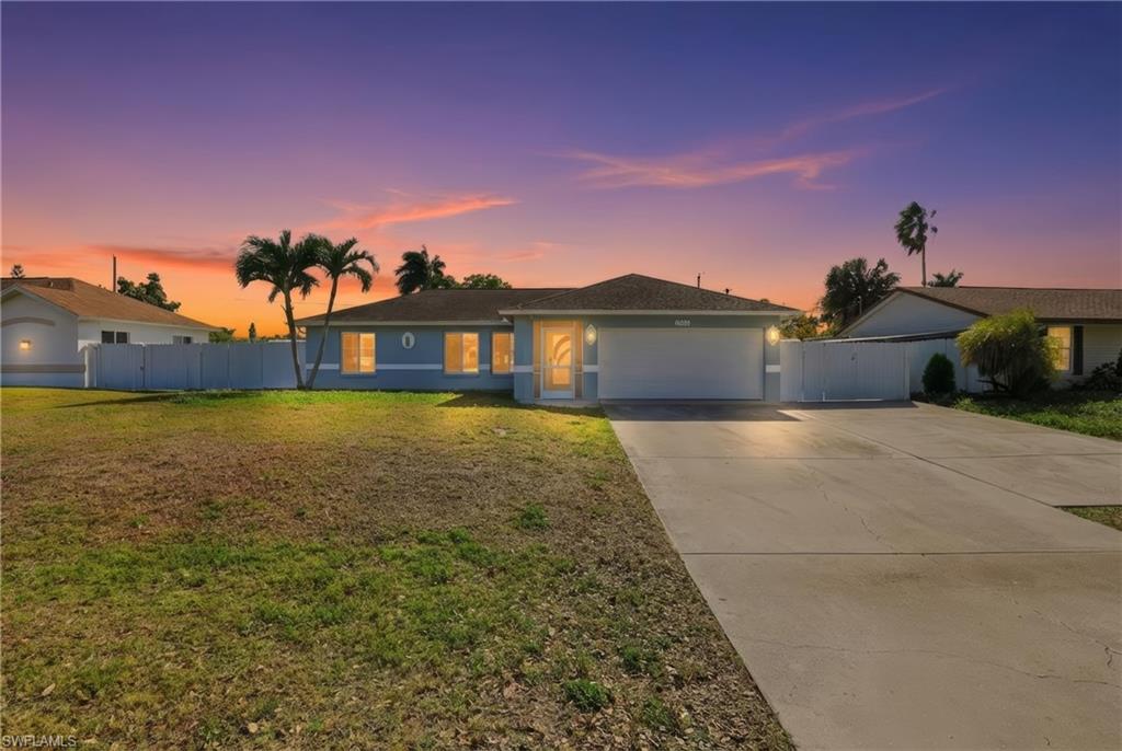 Single story home featuring concrete driveway, an attached garage, and stucco siding