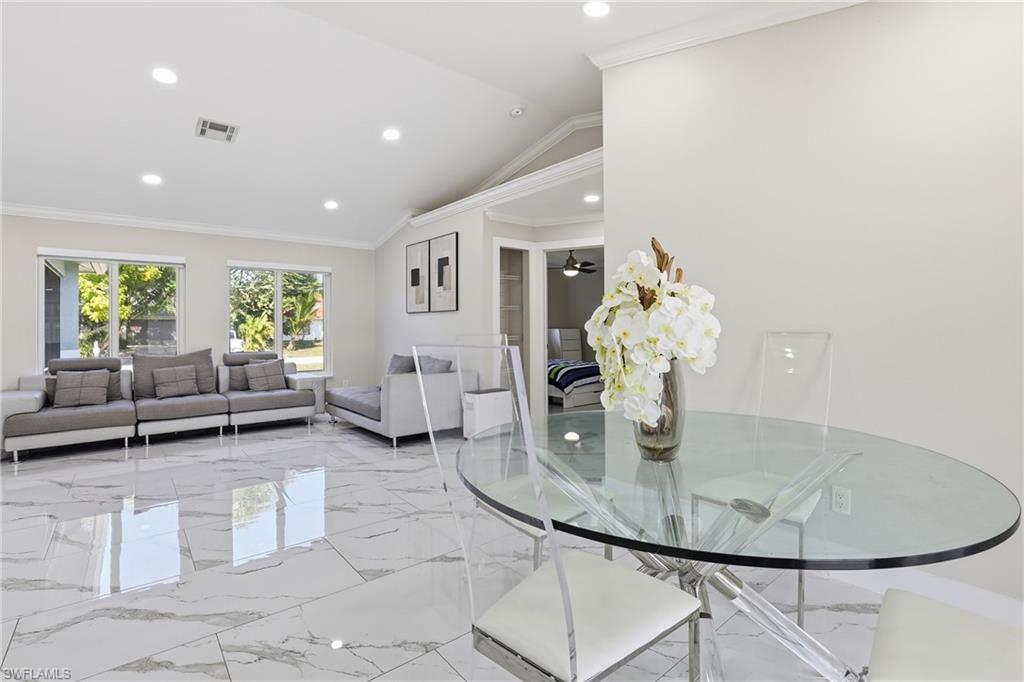 5312 17th Avenue Southwest Naples, FL 34116 - Photo 15 of 45 Dining space with crown molding, vaulted ceiling, recessed lighting, light marble finish floors, and ceiling fan