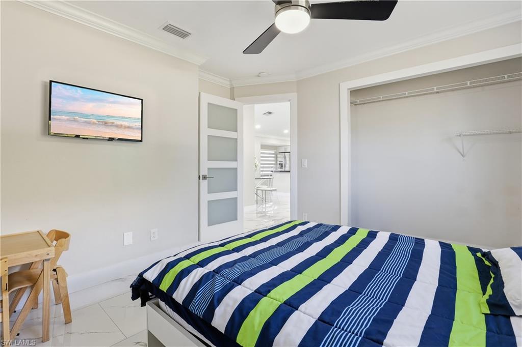 5312 17th Avenue Southwest Naples, FL 34116 - Photo 22 of 45 Bedroom with ornamental molding, light marble finish flooring, and a ceiling fan