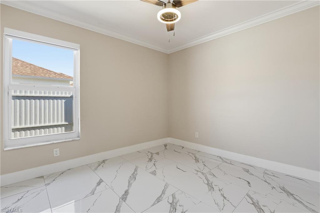 5312 17th Avenue Southwest Naples, FL 34116 - Photo 23 of 45 Spare room with crown molding, marble finish floors, and a ceiling fan