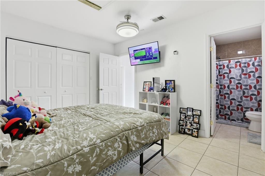 5312 17th Avenue Southwest Naples, FL 34116 - Photo 28 of 45 Bedroom with a closet, light tile patterned flooring, and ensuite bath