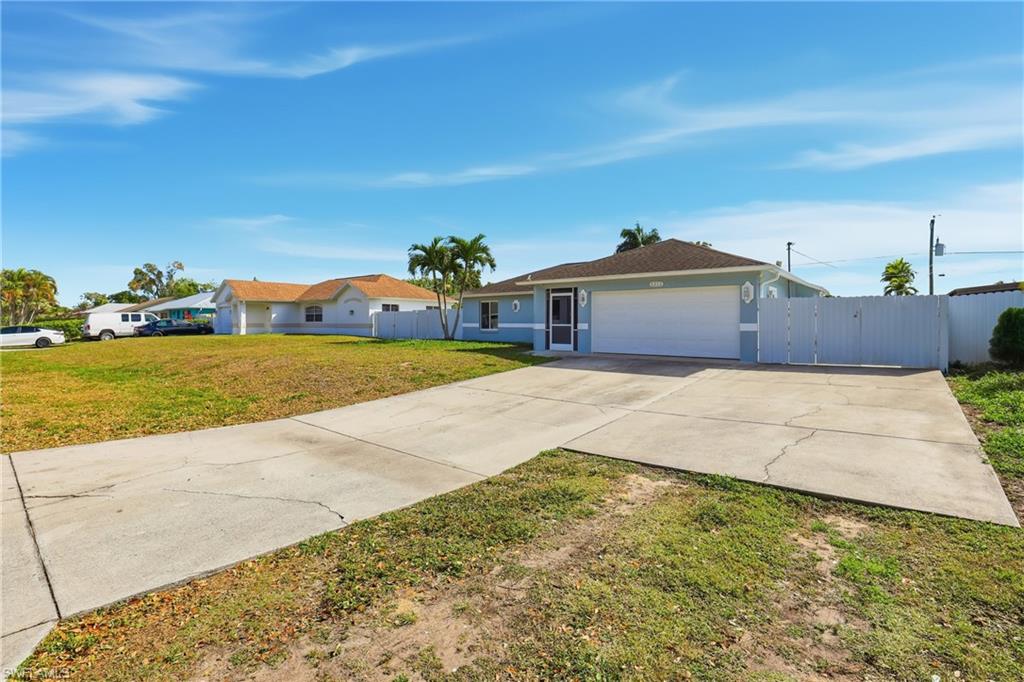 5312 17th Avenue Southwest Naples, FL 34116 - Photo 4 of 45 Ranch-style home with a gate, concrete driveway, a garage, and stucco siding