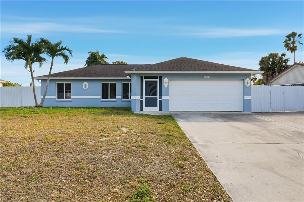 5312 17th Avenue Southwest Naples, FL 34116 - Photo 5 of 45 Ranch-style house with stucco siding, concrete driveway, roof with shingles, a garage, and a gate