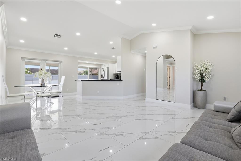 5312 17th Avenue Southwest Naples, FL 34116 - Photo 8 of 45 Living area featuring ornamental molding, arched walkways, recessed lighting, and lofted ceiling