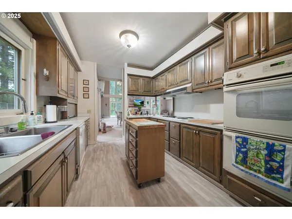 a kitchen with stainless steel appliances granite countertop a sink stove and wooden cabinets