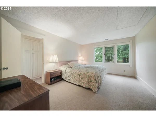 a spacious bedroom with a bed and a cabinets