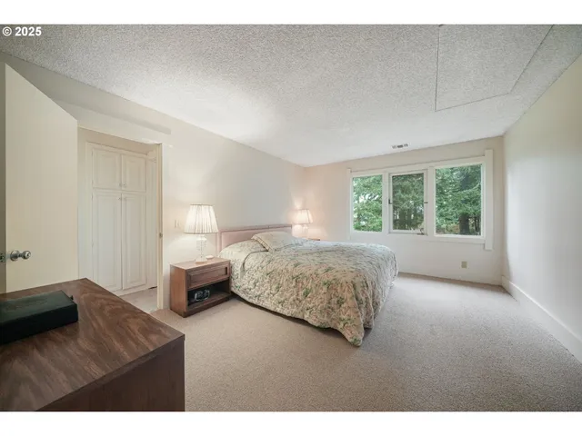 a spacious bedroom with a bed and a cabinets