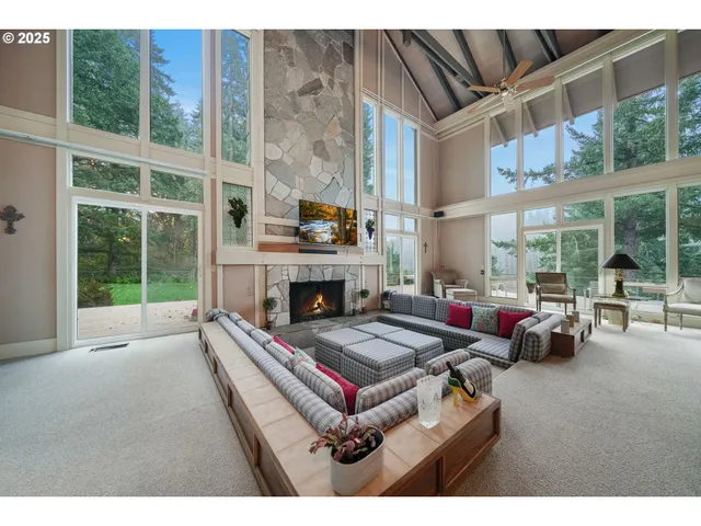 a living room with furniture fireplace and floor to ceiling windows