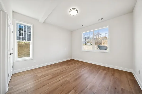 a view of an empty room with wooden floor
