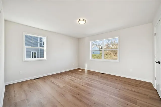 a view of an empty room with wooden floor