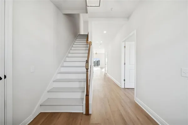 a view of a hallway with wooden floor and entryway