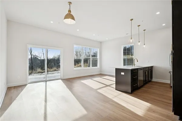 a view of a kitchen with wooden floor and outdoor space