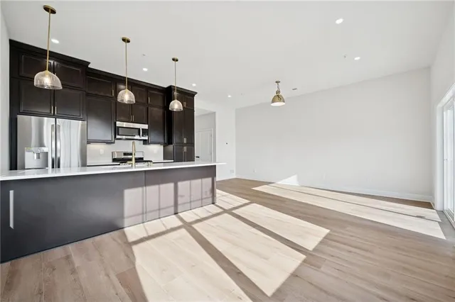 a large kitchen with stainless steel appliances kitchen island a large counter space a sink appliances and cabinets