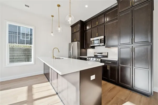 a kitchen with kitchen island a sink stainless steel appliances and cabinets