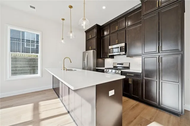 a kitchen with kitchen island a sink stainless steel appliances and cabinets