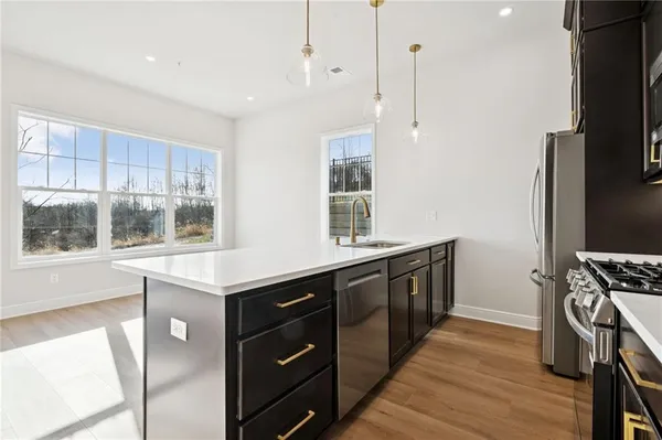 a kitchen with stainless steel appliances granite countertop a stove a sink and a refrigerator