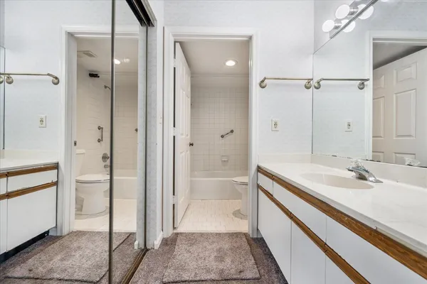 a white toilet and tub sitting next to a white cabinet