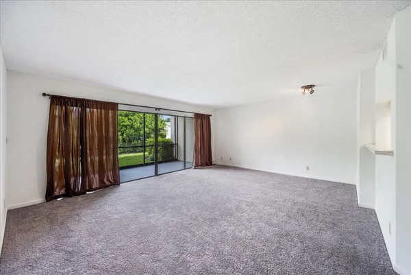 a view of a big room with windows and chandelier fan
