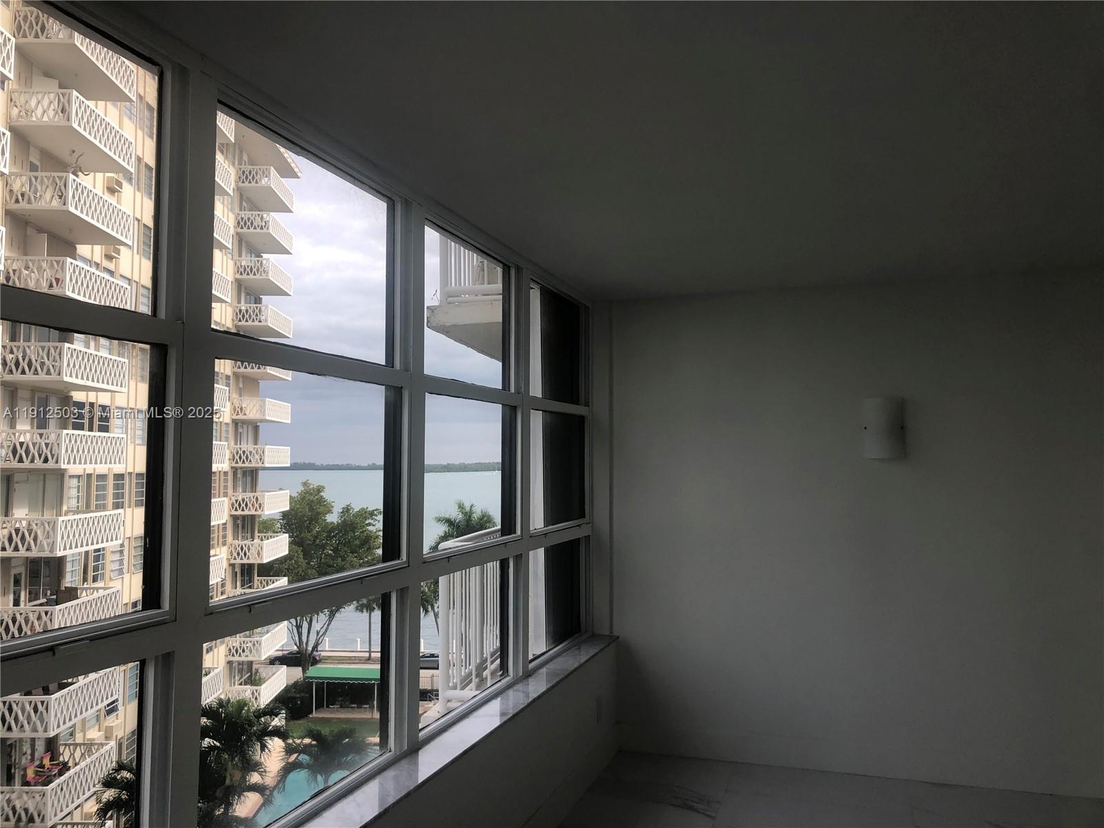 1440 Brickell Bay Drive, Unit 709 Miami, FL 33131 - Photo 12 of 13 an empty room with wooden floor and a window