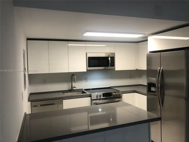 a kitchen with a refrigerator and a sink