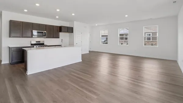 a view of kitchen with wooden floor and electronic appliances