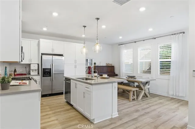 a kitchen with stainless steel appliances granite countertop a sink a counter space and living room view