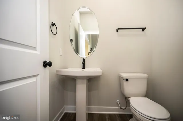 a bathroom with a toilet a sink and mirror