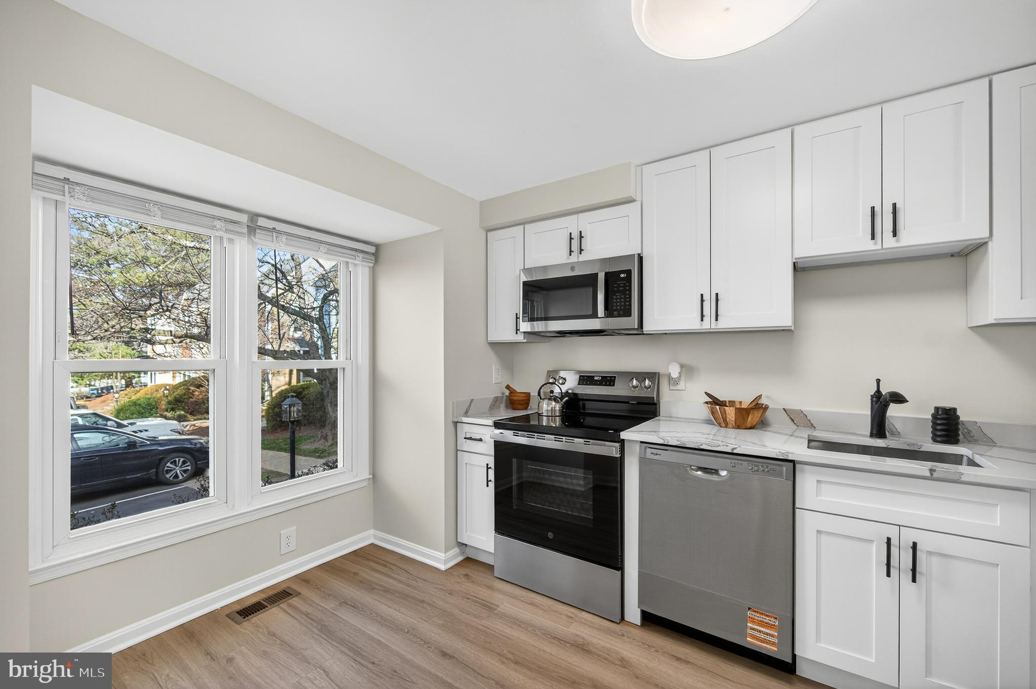11920 Redtree Way Reston, VA 20194 - Photo 2 of 42 a kitchen with stainless steel appliances granite countertop white cabinets a sink a stove a refrigerator and microwave with wooden floor