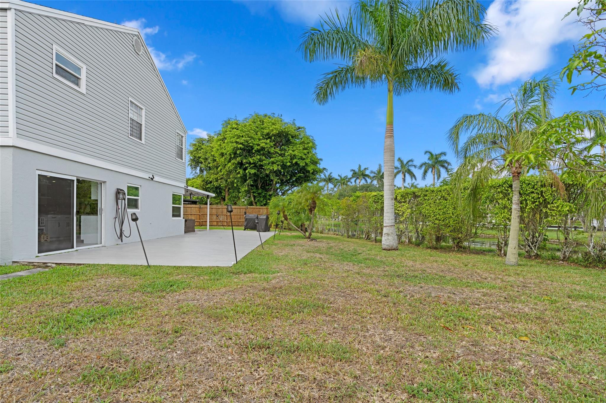 133 Southwest 159th Way Sunrise, FL 33326 - Photo 26 of 38 a white house with a big yard and palm trees