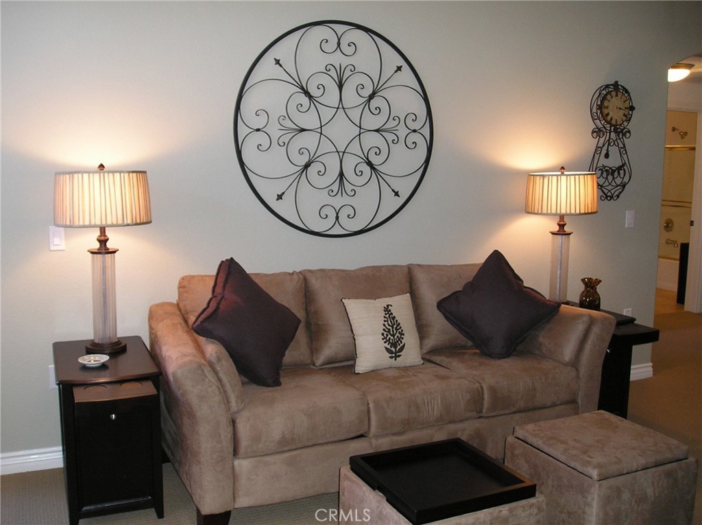 9293 Regents Road, Unit C303 La Jolla, CA 92037 - Photo 5 of 9 a living room with furniture a lamp and a large mirror on the wall