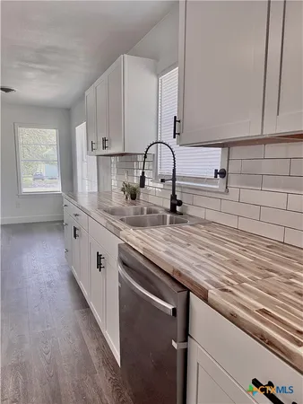 a kitchen with stainless steel appliances granite countertop a sink and wooden cabinets