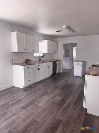 a large kitchen with a wooden floor and a sink