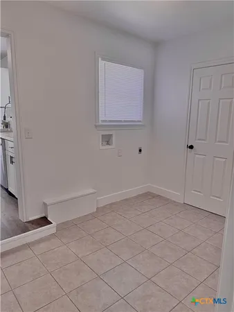 an empty room with wooden floor ceiling fan and windows