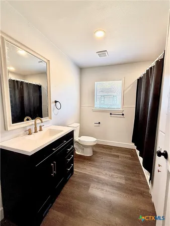 a bathroom with a sink a toilet a mirror and vanity