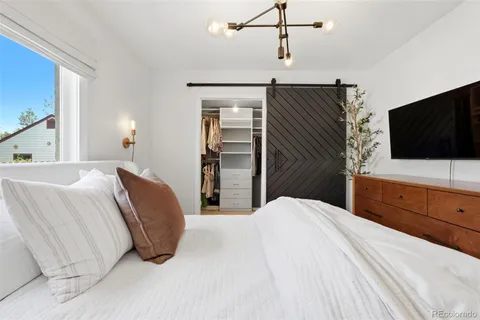 a bedroom with a bed and a flat screen tv