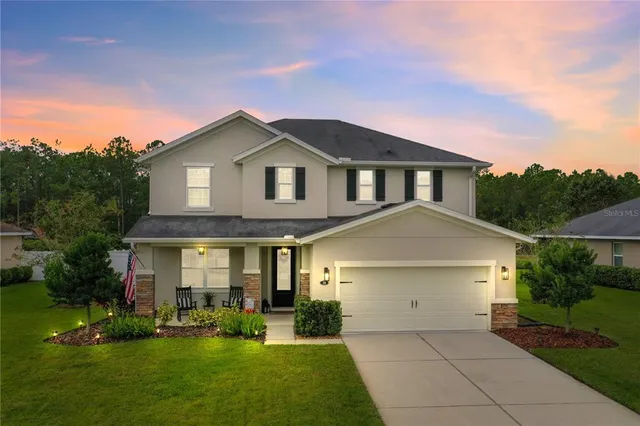 a front view of a house with yard and green space