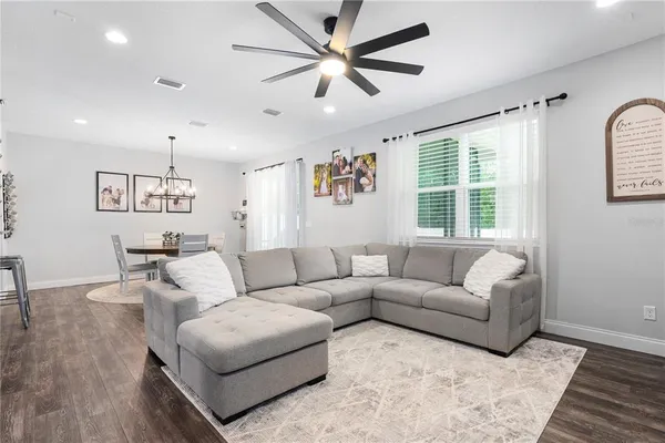 a kitchen with stainless steel appliances white cabinets a sink a stove a microwave and wooden floors