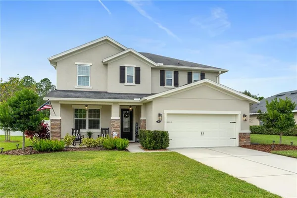 a front view of a house with a garden and yard